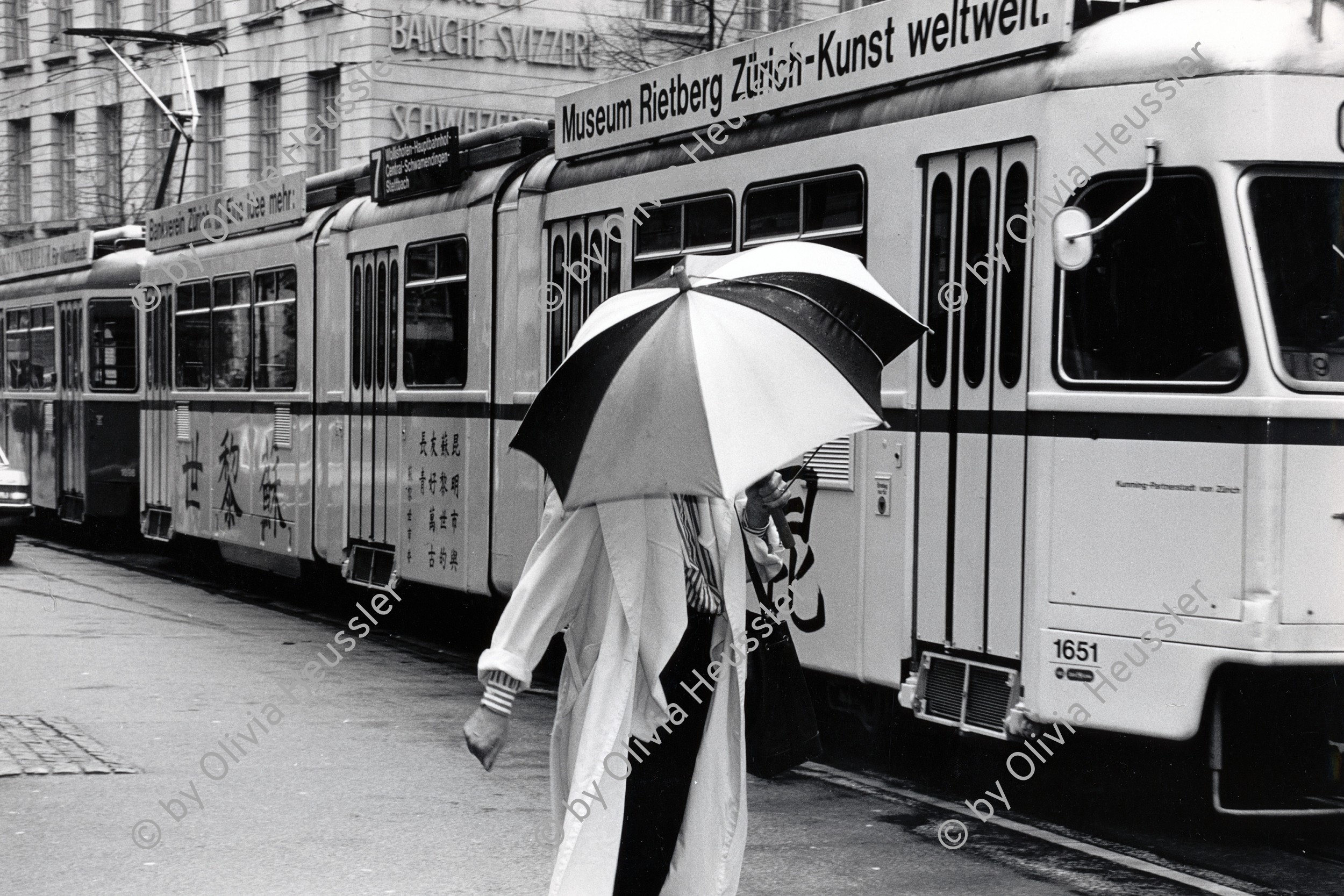 Image of sheet 19880250 photo 29: Szene an der Bahnhofstrasse. Frau unter Regenschirm. Mirage Tram In Strassenbahn Vor bemalter Strassenbahn. 
Zürich 1988 √