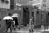 Image of sheet 19880250 photo 35: Szene an der Bahnhofstrasse. Frauen in Pelzmäntel unter Regenschirmen mit Hunden 
Granitskulptur (1983) von Max Bill
Der Schweizer Künstler Max Bill schuf 1983 die begehbare «Pavillon-Skulptur» – ein Beispiel für klare Linien –, die heute an erstklassiger Lage vor dem Zürcher Hauptsitz der Grossbank UBS an der Bahnhofstrasse steht. Die streng konzipierte, von Logik und Klarheit geprägte Konstruktion aus hochpolierten, grauen Granitelementen war anfänglich äusserst umstritten.
Bahnhofstrasse 
Zürich 1988 √