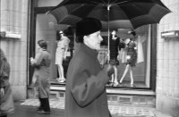 Image of sheet 19880270 photo 11: frstg. 880260        Damen plaisieren vor Schaufenster Damen unter Regenschirmen. Mann mit USA auf dem Rücken. Herren mit Hundchen. gefolgt von einem Hund. in Pelzmäntel an der Zürcher Bahnhofstrasse. Zürich 1988