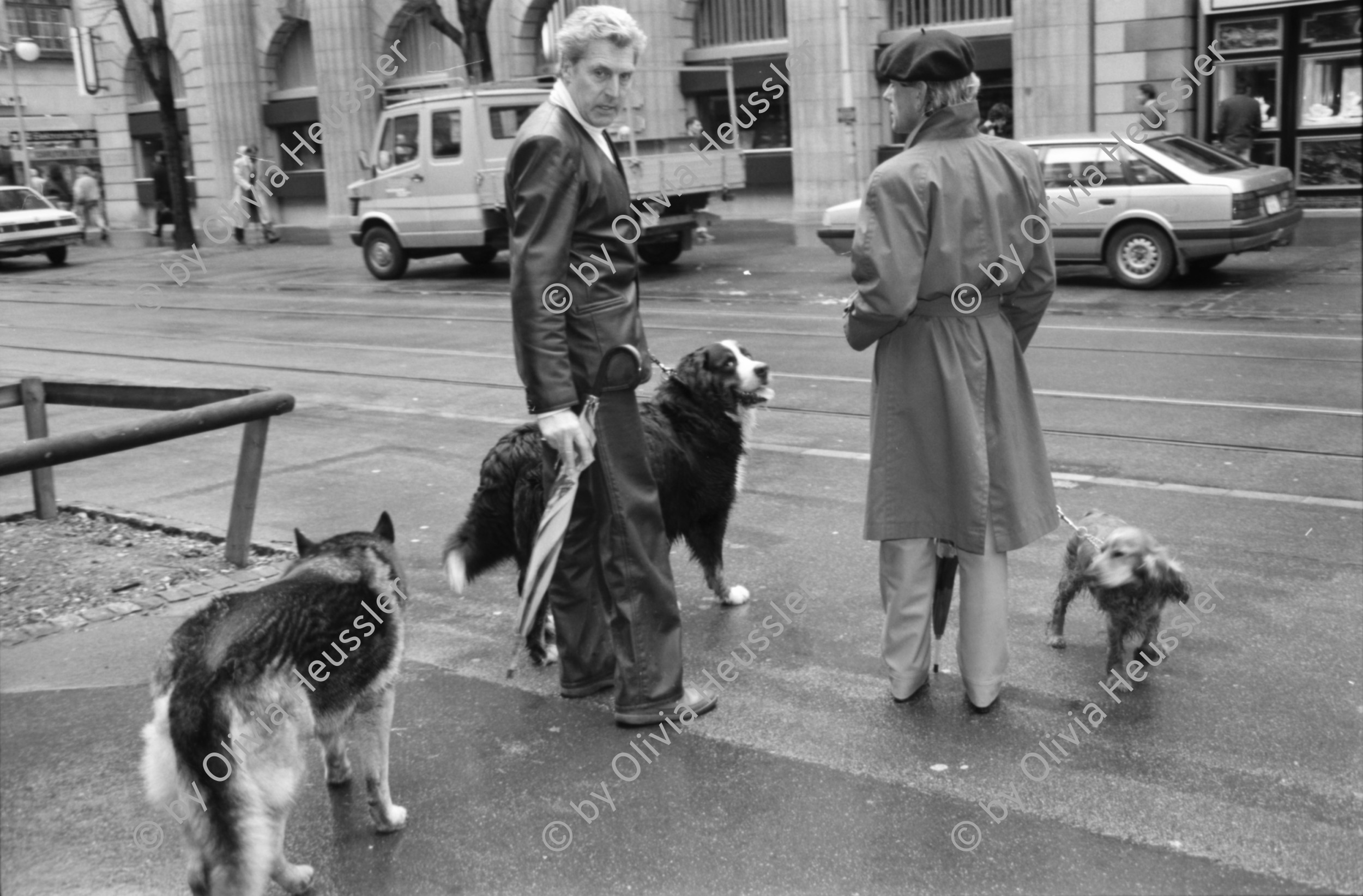 Image of sheet 19880270 photo 29: frstg. 880260        Damen plaisieren vor Schaufenster Damen unter Regenschirmen. Mann mit USA auf dem Rücken. Herren mit Hundchen. gefolgt von einem Hund. in Pelzmäntel an der Zürcher Bahnhofstrasse. Zürich 1988
