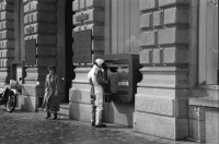 Image of sheet 19880280 photo 18: frtsg. 880270 Am Paradeplatz zeichnen junge Mädchen. zwei alte Damen. Jetzt weniger Autofahren und Heizen. Kampagne gegen schlechte Luft der Stadt Zürich. Mann hält sich Nase zu. Mann mit Helm und Leder Kombi holt sich am Bancomat Geld ab. Mann und Frau mit Kind in Babykorb. Nonne steht daneben. Mercedes Benz fährt durch die Strasse. Häuser spiegeln sich in Fenster. Orthodoxer jüdischer Jude Mann auf Moped studiert die Börsenkurse. Passanten Bankeingang. UBS Junge Frau an VBZ Haltestelle macht ein komisches Gesicht. Frauen und Strassenbahn. Bahnhofstrasse Zürich 1988