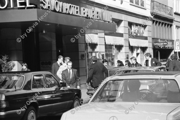 Image of sheet 19880290 photo 18: frtsg. 880280  Filmstreifen Rollen als Dekoration in Migros City Löwenstrasse Junge bestaunen Motorrad. Mann steht an Bahnhofstafel. Bahnhofstrasse 1988 Dame mit Sonnenbrille. Passanten. Vor Hotel beladen Männer Mercedes Benz. Mann und Frau dramatisch im Licht und in Bewegung von unten gehen am Paradeplatz. Bewegungen mit Auto. Frau entsorgt Abfall. Gruppe in Mäntel elegant. Zürich 1988