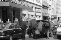Image of sheet 19880290 photo 19: frtsg. 880280  Filmstreifen Rollen als Dekoration in Migros City Löwenstrasse Junge bestaunen Motorrad. Mann steht an Bahnhofstafel. Bahnhofstrasse 1988 Dame mit Sonnenbrille. Passanten. Vor Hotel beladen Männer Mercedes Benz. Mann und Frau dramatisch im Licht und in Bewegung von unten gehen am Paradeplatz. Bewegungen mit Auto. Frau entsorgt Abfall. Gruppe in Mäntel elegant. Zürich 1988
