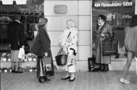 Image of sheet 19880300 photo 11: frtsg. 880290 Pelzmäntel. Geschäftsmann ruht sich aus. Dame in Bewegung. Damen mit Hund. Bei Sprüngli fotografiert ein Tourist mit dickem Bauch Damen vor Reisebüro SBB- Strassenbahn Tram Dame kokettiert. Bewegungen mit Auto. Verkehrs Polizei gibt Busse. Vor Gübelin. Im Regen rennen die Leute über den Paradeplatz. Die Strassenbahn hält. Bahnhofstrasse Zürich 1988