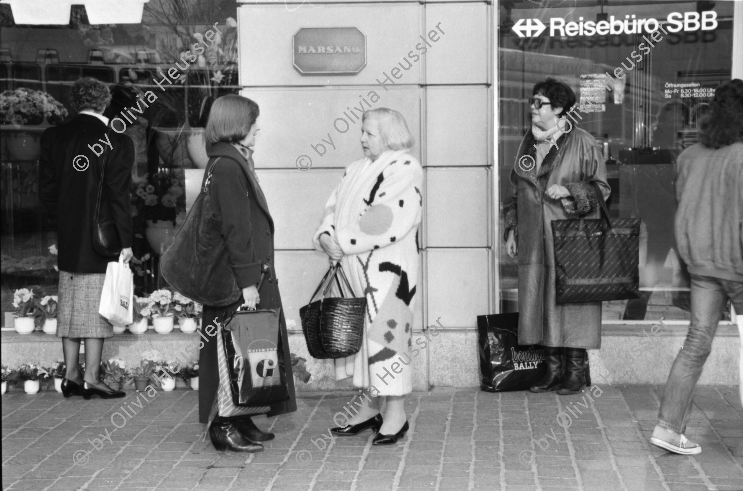 Image of sheet 19880300 photo 11: frtsg. 880290 Pelzmäntel. Geschäftsmann ruht sich aus. Dame in Bewegung. Damen mit Hund. Bei Sprüngli fotografiert ein Tourist mit dickem Bauch Damen vor Reisebüro SBB- Strassenbahn Tram Dame kokettiert. Bewegungen mit Auto. Verkehrs Polizei gibt Busse. Vor Gübelin. Im Regen rennen die Leute über den Paradeplatz. Die Strassenbahn hält. Bahnhofstrasse Zürich 1988