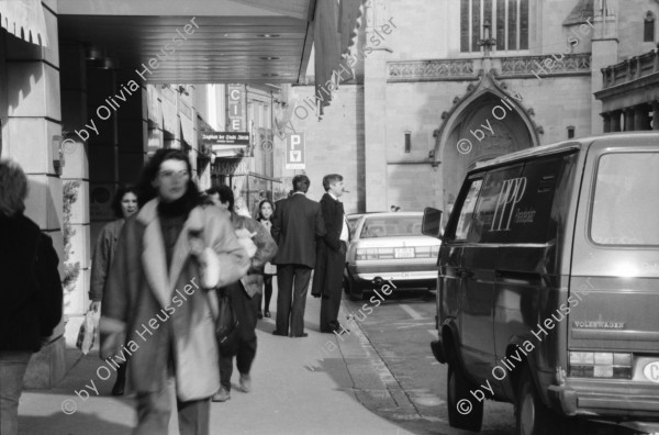 Image of sheet 19880300 photo 2: frtsg. 880290 Pelzmäntel. Geschäftsmann ruht sich aus. Dame in Bewegung. Damen mit Hund. Bei Sprüngli fotografiert ein Tourist mit dickem Bauch Damen vor Reisebüro SBB- Strassenbahn Tram Dame kokettiert. Bewegungen mit Auto. Verkehrs Polizei gibt Busse. Vor Gübelin. Im Regen rennen die Leute über den Paradeplatz. Die Strassenbahn hält. Bahnhofstrasse Zürich 1988