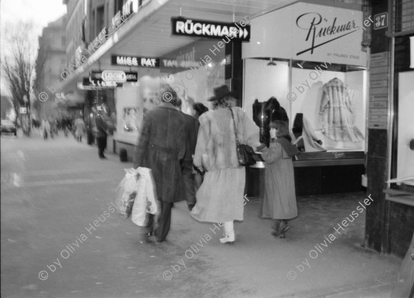 Image of sheet 19880300 photo 24: frtsg. 880290 Pelzmäntel. Geschäftsmann ruht sich aus. Dame in Bewegung. Damen mit Hund. Bei Sprüngli fotografiert ein Tourist mit dickem Bauch Damen vor Reisebüro SBB- Strassenbahn Tram Dame kokettiert. Bewegungen mit Auto. Verkehrs Polizei gibt Busse. Vor Gübelin. Im Regen rennen die Leute über den Paradeplatz. Die Strassenbahn hält. Bahnhofstrasse Zürich 1988