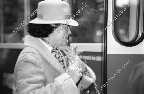 Image of sheet 19880300 photo 29: frtsg. 880290 Pelzmäntel. Geschäftsmann ruht sich aus. Dame in Bewegung. Damen mit Hund. Bei Sprüngli fotografiert ein Tourist mit dickem Bauch Damen vor Reisebüro SBB- Strassenbahn Tram Dame kokettiert. Bewegungen mit Auto. Verkehrs Polizei gibt Busse. Vor Gübelin. Im Regen rennen die Leute über den Paradeplatz. Die Strassenbahn hält. Bahnhofstrasse Zürich 1988