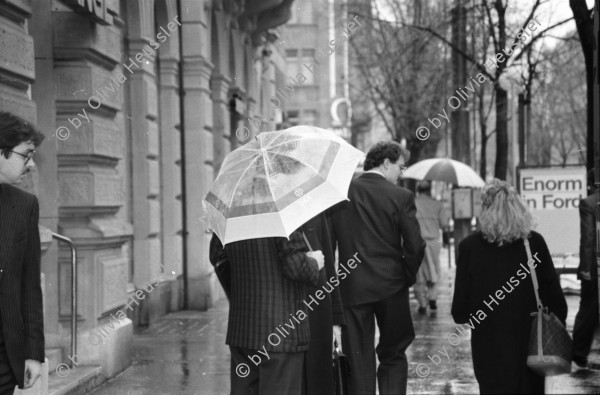 Image of sheet 19880310 photo 25: frtsg. 880300 Bewegung auf dem Paradeplatz an der Zürcher Bahnhofstrasse, es regnet die Menschen rennen gestresst durch den Regen. Unter dem Regenschirm einstellen von täglichem Schadstoffpegel. Unter Regenschirmen Bewegung. Mit Strassenbahn PassantInnen. Zwei Knaben in Strassenbahn. Tram Zürich 1988