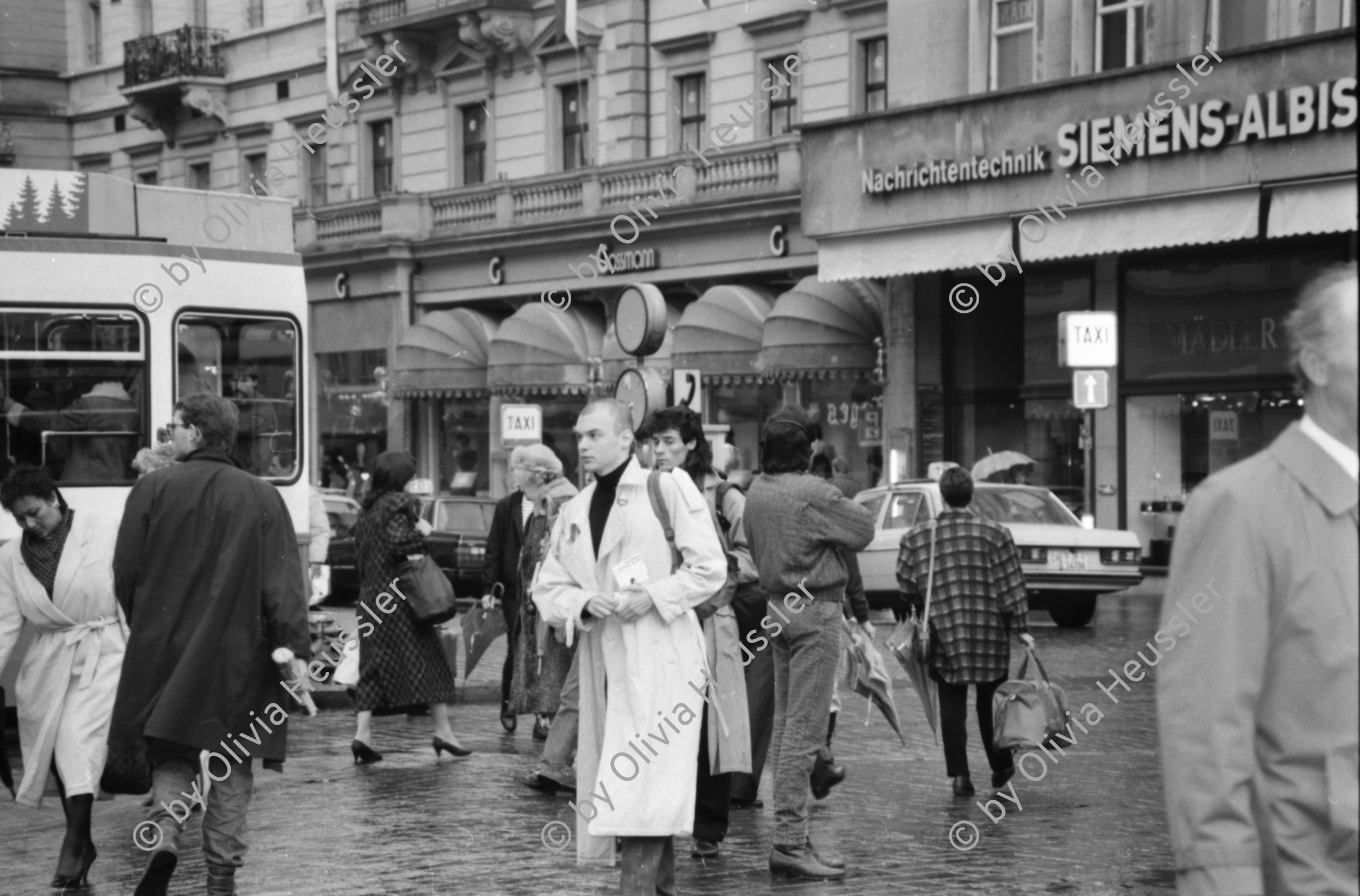 Image of sheet 19880310 photo 31: Bewegung auf dem Paradeplatz an der Zürcher Bahnhofstrasse, es regnet die Menschen rennen gestresst durch den Regen. Unter dem Regenschirm Regenschirmen Bewegung. PassantInnen. Kreis 1 Paradeplatz Zürich 1988 √