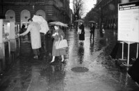 Image of sheet 19880310 photo 5: frtsg. 880300 Bewegung auf dem Paradeplatz an der Zürcher Bahnhofstrasse, es regnet die Menschen rennen gestresst durch den Regen. Unter dem Regenschirm einstellen von täglichem Schadstoffpegel. Unter Regenschirmen Bewegung. Mit Strassenbahn PassantInnen. Zwei Knaben in Strassenbahn. Tram Zürich 1988