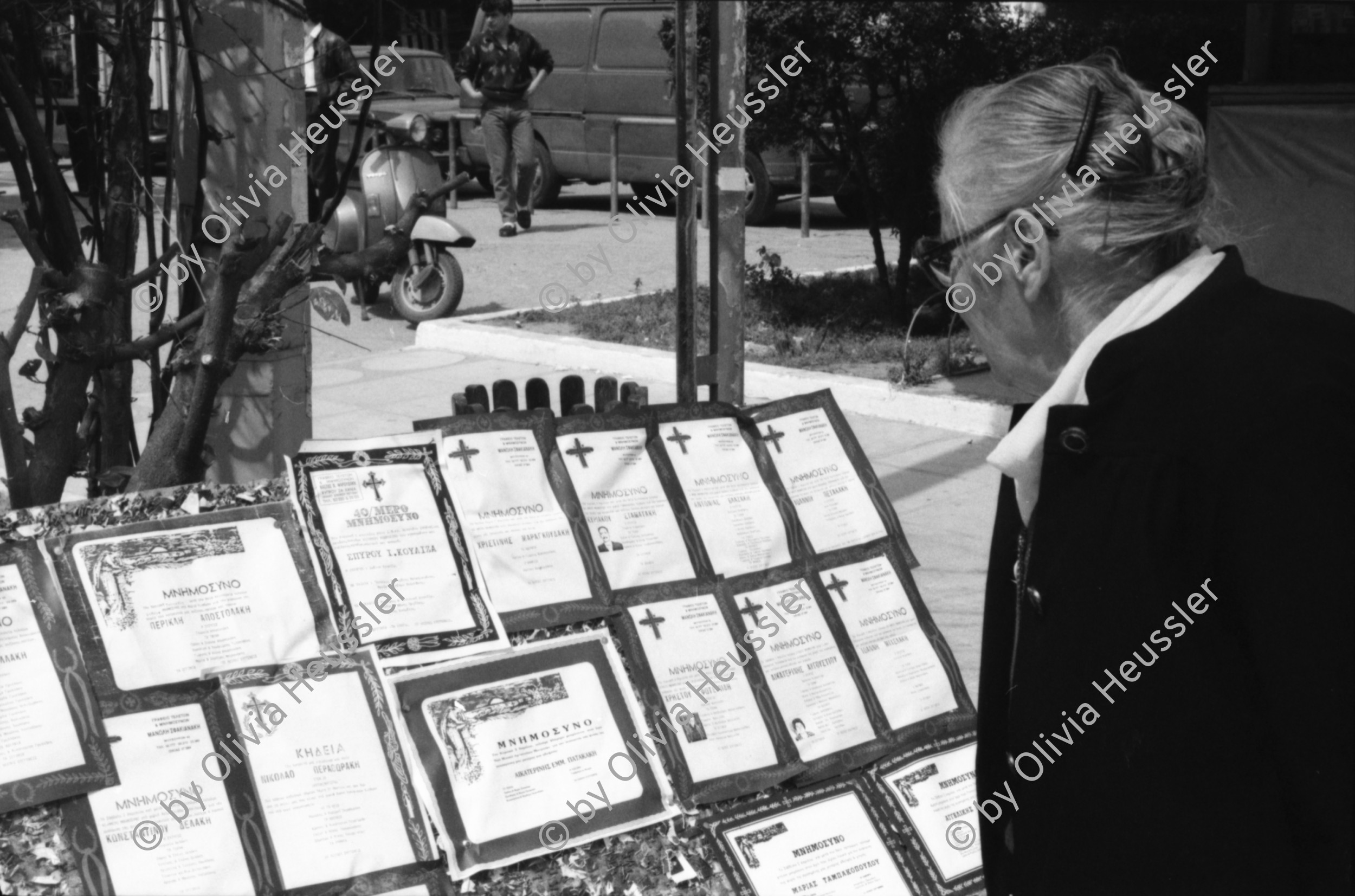 Image of sheet 19880330 photo 14: Plakate mit Frauenfeindlicher Reklame. Im Erismannhof steht Hallo Margrit du schöne Frauen - Wandmalerei. ABB Reklame im Flughafen Zürich. 
In Kreta mit Rudi Berli. Portrait. Frau studiert Todesanzeigen. Plakat der Nea Democratica. Mit Cathy auf dem Boot. mit Costa. Portrait Olivia. Haus typisch. Cathy und Mann X am Strand. Touristen Souvenir auf Autokühlerhaube. Dorf. Xania
Griechenland 1988