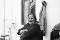 Image of sheet 19880350 photo 9: frtsg. 880340 Tassos Mutter Mara Cathy und Tassos Vater im Gewächshaus.  Alte Bäuerin in Schwarz Frauen an Bushaltestelle. Portrait Frau in Busshaltestelle. Am Buss. Meeresbucht von oben. altes Steinhaus. Portrait Daniela Venegoni und Tobias Eugster Hippie. Daniela mit vehülltem Kopf nackt am Strand. Dani und Tobias. Tobias. Gefängnis von Galatas. Mann grilliert Schaf. Kreta Griechenland 1988