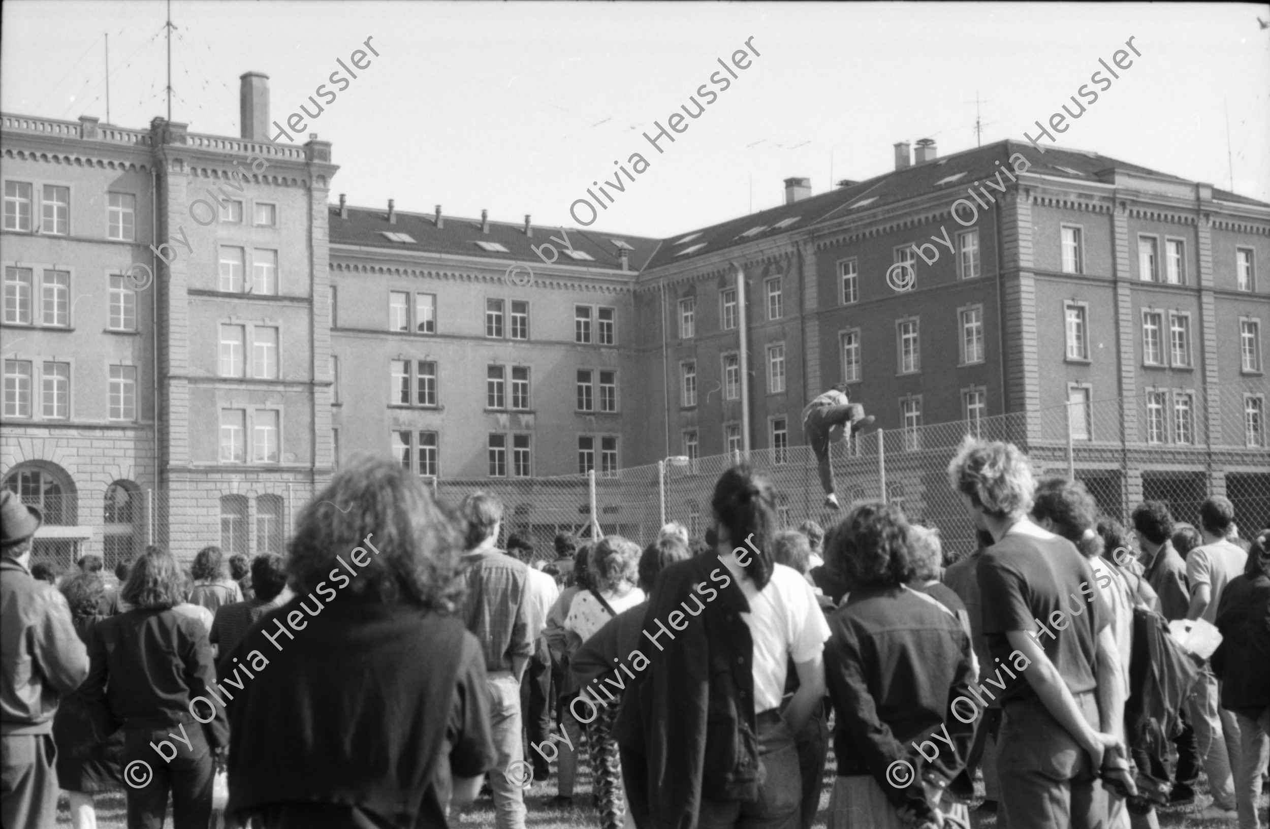 Image of sheet 19880380 photo 19: Iren Stehli und ein Freund. Fest  1. Mai. im Kaserne Innenhof. Mit älteren Besuchern Plakat von kurdischem ermordeten Kämpfer hängt an der Skulptur. Kinderfest Kaserne. Schwarze stehen am Gitterzaun hinter der Kaserne. Kurdische und Türkische AsylantInnen protestieren gegen die Inhaftierung von ihren Genossen. und Kollegen. Sie zünden Petarden an, die sie gegen die Polizeikaserne richten. Fredy Meier. Zürich 1988 Kreis vier Kurds 
Schweiz Switzerland Swiss protest