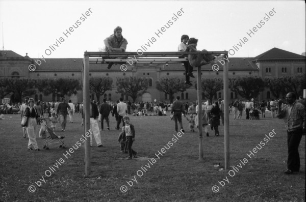 Image of sheet 19880380 photo 26: Iren Stehli und ein Freund. Fest  1. Mai. im Kaserne Innenhof. Mit älteren Besuchern Plakat von kurdischem ermordeten Kämpfer hängt an der Skulptur. Kinderfest Kaserne. Schwarze stehen am Gitterzaun hinter der Kaserne. Kurdische und Türkische AsylantInnen protestieren gegen die Inhaftierung von ihren Genossen. und Kollegen. Sie zünden Petarden an, die sie gegen die Polizeikaserne richten. Fredy Meier. Zürich 1988 Kreis vier Kurds 
Schweiz Switzerland Swiss protest