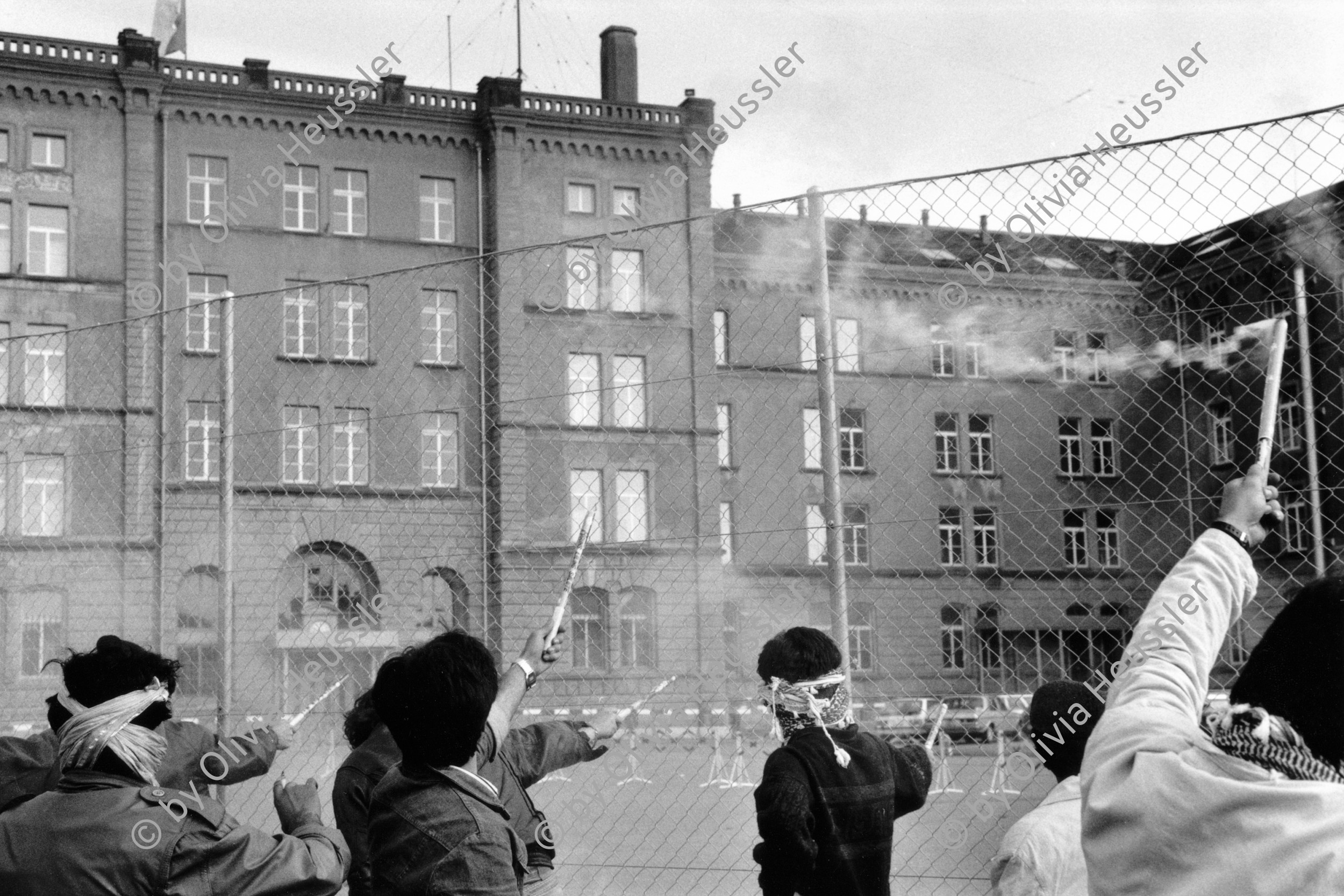 Image of sheet 19880380 photo 32: Jugendliche protestieren mit Knallkoerper am 1. Mai bei der Kaserne gegen die Verhaftung eines Freundes, Zuerich 1988. 
prison fence protest fyer feuerwerke