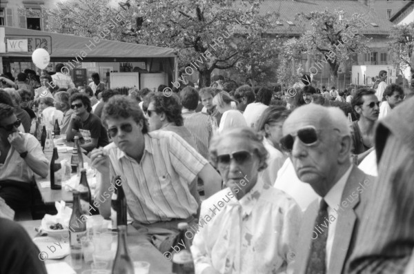 Image of sheet 19880380 photo 5: Iren Stehli und ein Freund. Fest  1. Mai. im Kaserne Innenhof. Mit älteren Besuchern Plakat von kurdischem ermordeten Kämpfer hängt an der Skulptur. Kinderfest Kaserne. Schwarze stehen am Gitterzaun hinter der Kaserne. Kurdische und Türkische AsylantInnen protestieren gegen die Inhaftierung von ihren Genossen. und Kollegen. Sie zünden Petarden an, die sie gegen die Polizeikaserne richten. Fredy Meier. Zürich 1988 Kreis vier Kurds 
Schweiz Switzerland Swiss protest