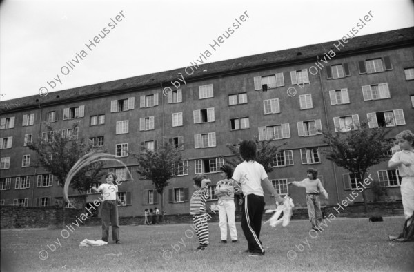 Image of sheet 19880411 photo 16: Susan Büchi malt ein Transparent und Dorothea Hunziker. Wäsche hängt im Erismannhof Innenhof städtische Siedlung Erismannhof Kinder spielen mit Papier Kugeln. 
Die Siedlung vor dem Umbau mit Kinder im Vordergrund.
Zürich 1988