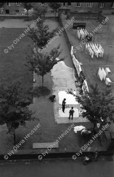 Image of sheet 19880411 photo 6: Susan Büchi malt ein Transparent und Dorothea Hunziker. Wäsche hängt im Erismannhof Innenhof städtische Siedlung Erismannhof Kinder spielen mit Papier Kugeln. 
Die Siedlung vor dem Umbau mit Kinder im Vordergrund.
Zürich 1988