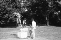 Image of sheet 19880691 photo 15: Ausstellung Walter Martin Plakat Kunst Bildhauerei Plastik wird von Leuten besucht. Yasmina, die Tochter von Christiane Barckhausen Canale sitzt auf einer Plastik. Figur. Das Konzerthaus in Berlin wird renoviert. An der Schutzwand während der Bauerei hängen Plakate wie sie aussehen soll. Ein spritzt lange Treppe mit Wasser ab. Vor einem Laden stehen Holzharasse. Gunhild Brandler verdeckt sich das Gesicht. Unter dem Titel 'Lieber Sonne im Herzen' organisiert die FDJ Freie Deutsche Jugend den diesjährigen Liedersommer auf der Insel der Jugend. Eine junge blonde FDJ lerin sitzt  mit Netzstrümpfen da. Ihr Genosse will nicht das ich sie fotografiere und macht sich springbereit. Uebersicht auf das Zelt. Da steht eine  Plastik. Berlin Ost Deutschland 1988