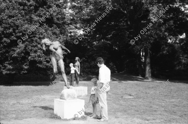 Image of sheet 19880691 photo 15: Ausstellung Walter Martin Plakat Kunst Bildhauerei Plastik wird von Leuten besucht. Yasmina, die Tochter von Christiane Barckhausen Canale sitzt auf einer Plastik. Figur. Das Konzerthaus in Berlin wird renoviert. An der Schutzwand während der Bauerei hängen Plakate wie sie aussehen soll. Ein spritzt lange Treppe mit Wasser ab. Vor einem Laden stehen Holzharasse. Gunhild Brandler verdeckt sich das Gesicht. Unter dem Titel 'Lieber Sonne im Herzen' organisiert die FDJ Freie Deutsche Jugend den diesjährigen Liedersommer auf der Insel der Jugend. Eine junge blonde FDJ lerin sitzt  mit Netzstrümpfen da. Ihr Genosse will nicht das ich sie fotografiere und macht sich springbereit. Uebersicht auf das Zelt. Da steht eine  Plastik. Berlin Ost Deutschland 1988