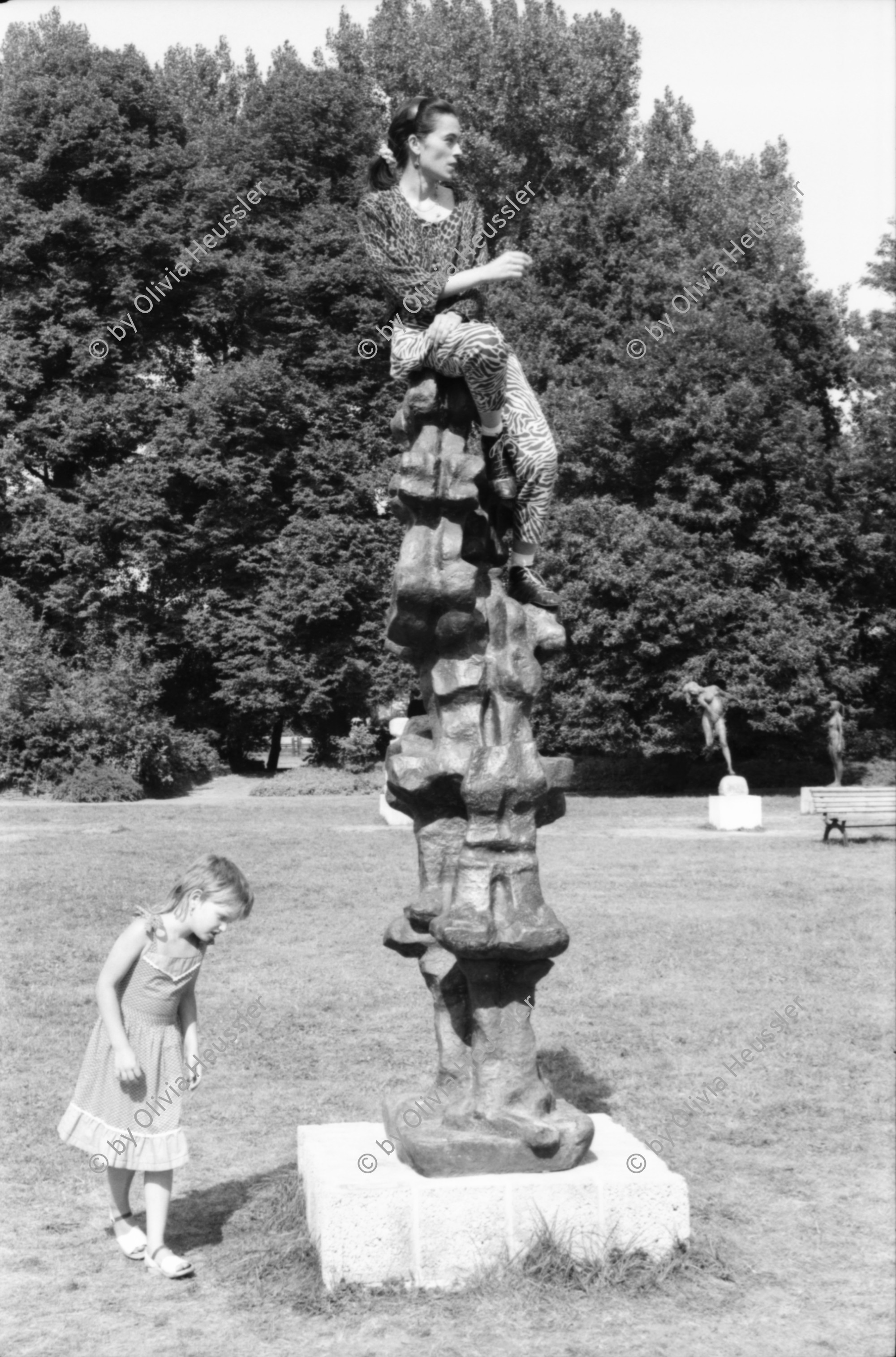 Image of sheet 19880691 photo 19: Ausstellung Walter Martin Plakat Kunst Bildhauerei Plastik wird von Leuten besucht. Yasmina, die Tochter von Christiane Barckhausen Canale sitzt auf einer Plastik. Figur. Das Konzerthaus in Berlin wird renoviert. An der Schutzwand während der Bauerei hängen Plakate wie sie aussehen soll. Ein spritzt lange Treppe mit Wasser ab. Vor einem Laden stehen Holzharasse. Gunhild Brandler verdeckt sich das Gesicht. Unter dem Titel 'Lieber Sonne im Herzen' organisiert die FDJ Freie Deutsche Jugend den diesjährigen Liedersommer auf der Insel der Jugend. Eine junge blonde FDJ lerin sitzt  mit Netzstrümpfen da. Ihr Genosse will nicht das ich sie fotografiere und macht sich springbereit. Uebersicht auf das Zelt. Da steht eine  Plastik. Berlin Ost Deutschland 1988