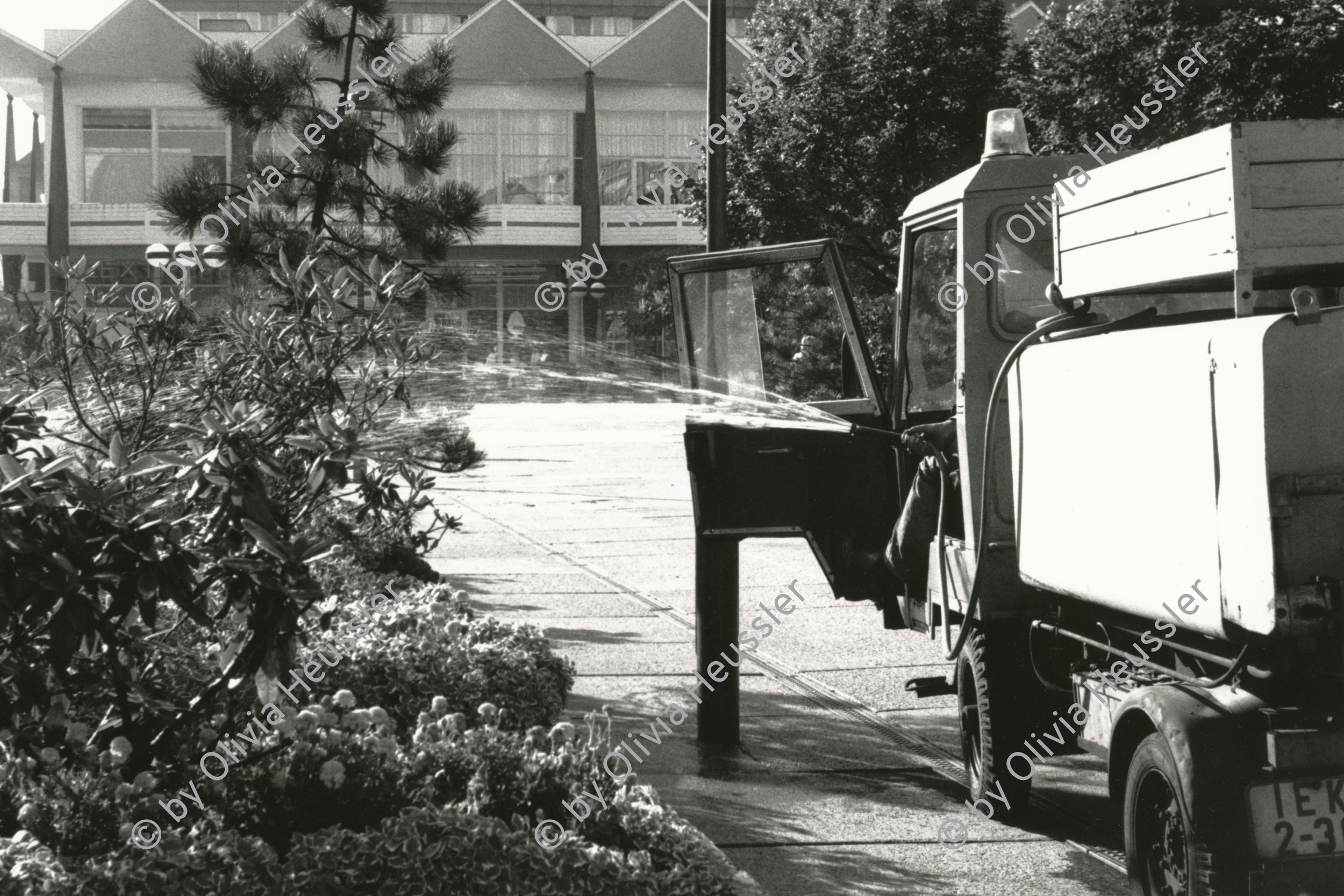 Image of sheet 19880693 photo 36: Alexanderplatz Mann in Fahrzeug Maschine spritzt die Pflanzen auf dem Alexanderplatz. Der Mann sitzt im Gefährt und hält den Schlauch aus dem fahrenden Tankwagen. GDR DDR Deutschland Ost Ostdeutschland Ostberlin 1988 √