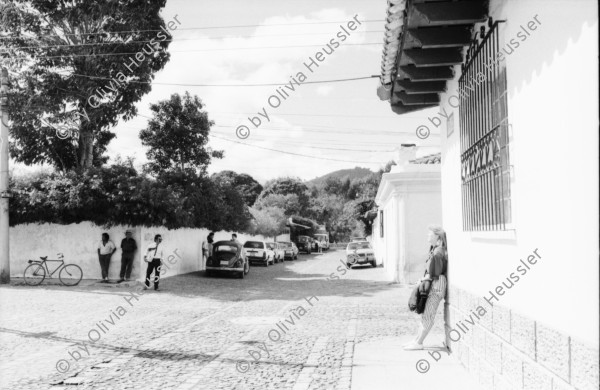 Image of sheet 19880900 photo 34: frtsg. 880890 Seminar FUNDES in Antigua. Hund sitzt auf Balkon. Frau auf der Strasse. Pflastersteinstrasse. Kind verkauft Kinderspielzeuge. Kirchen Eingang. Alte Frau bettelt. Familie kommt aus Kirche. Kirche wird saniert. Bethlehem Wandteppich hängt in Kirche. Mann putzt Kanzel. Pflanzen werden transportiert. Im Hotel Antigua. Guatemala 1988