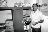 Image of sheet 19880960 photo 21: Duralita. Eternit Tochter. schmidheiny Holcim 
Der Sekretär  und Vertreterder Solidarismo Gewerkschaft in der von der Firma zur Verfügung gestellten Verwaltungsbaracke. Billige Einkaufsmöglichkeiten für Mitglieder,gibt auch Nestlé Milch an die Arbeiter ab.  Seine Baracke besteht aus Eternitelementen mit Asbest Dach. Guatemala 1988 √
© 1988, by OLIVIA HEUSSLER / www.clic.li 
Aus: Besichtigung der Hinterhöfe/Rotpunktverlag rpv und WOZ