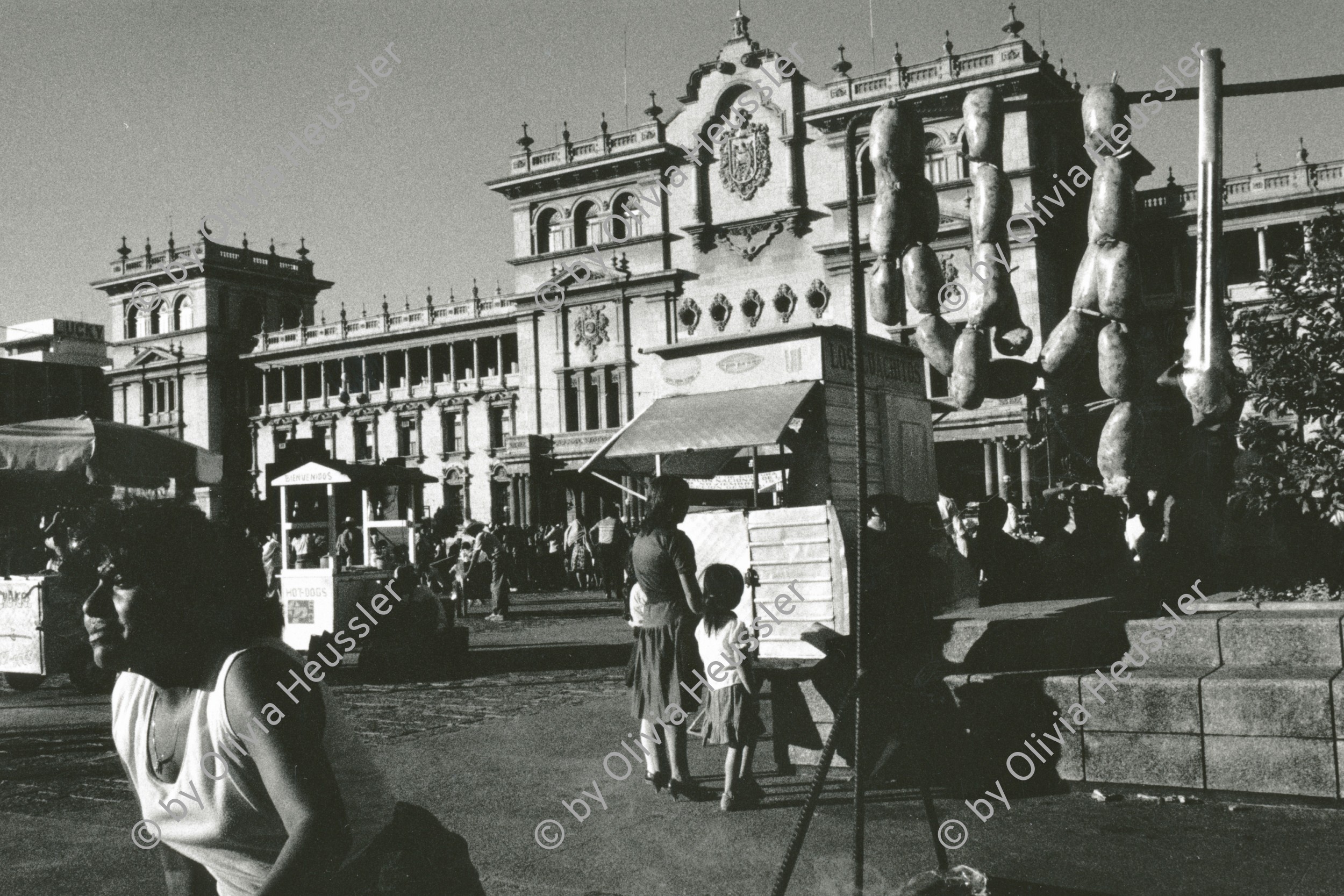 Image of sheet 19881000 photo 12: Markt verkäuferin Mit Würsten auf der Plaza de Gobierno Guatemala City. 12.88 1988 √ 
market saugage Würste meat Fleisch Regierungs palast platz woman verkauf young 
Aus: Besichtigung der Hinterhöfe/rpv WOZ
Out of: From time to time  / Von Zeit zu Zeit
Exhibition