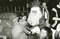 Image of sheet 19881010 photo 8: Die Regierung versucht mit allen Mitteln den Strassenkindern ein schönes Weihnachtsfest zu halten. Junges Mädchen mit Baby im Tuch begrüsst an Weihnachten Santa Nicolaus Den Weihnachtsmann Er verschenkt Spielzeug. Guatemala City 12.88 1988 √
