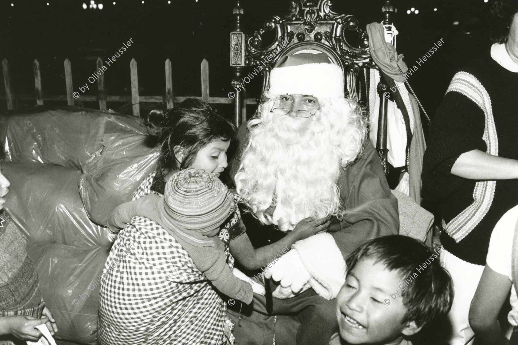 Image of sheet 19881010 photo 8: Die Regierung versucht mit allen Mitteln den Strassenkindern ein schönes Weihnachtsfest zu halten. Junges Mädchen mit Baby im Tuch begrüsst an Weihnachten Santa Nicolaus Den Weihnachtsmann Er verschenkt Spielzeug. Guatemala City 12.88 1988 √