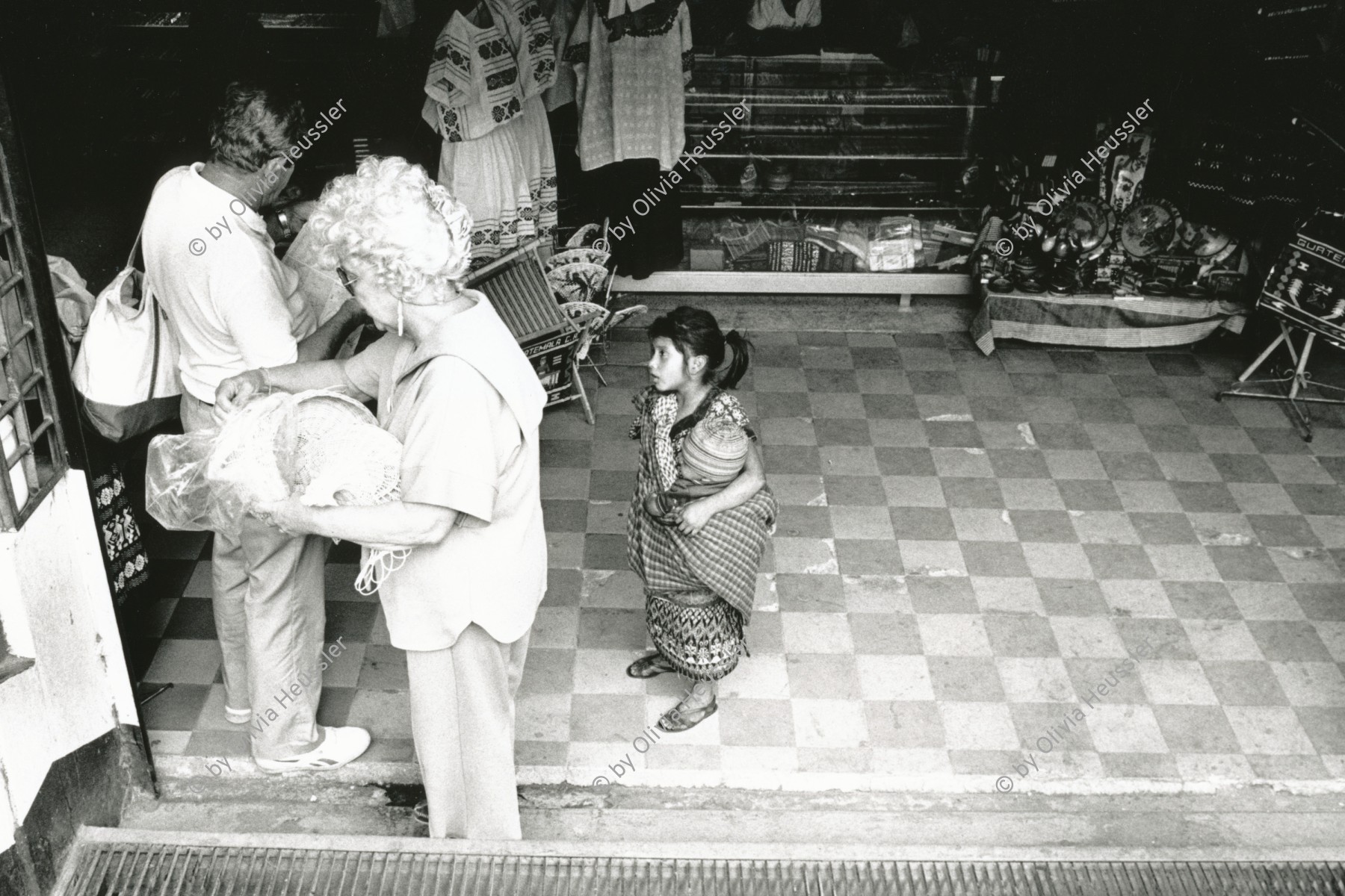 Image of sheet 19881020 photo 13: Strassenszene. Beim Mercado Central. kleines Mädchen mit kleinem Geschwisterchen in Tragtuch gewickelt bettelt bei US-Amerikanischen Touristen. Im Markt. Guatemala Stadt City √ 1988 turist indigena indio girl with baby
© 1988, by OLIVIA HEUSSLER / www.clic.li