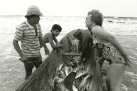 Image of sheet 19881080 photo 29: Eine Touristin erkundigt sich bei den Fischern um ihre Beute. Einem Haifisch, dem die Flossen bereits abgetrennt wurden. Fischmarkt Export. Nicaragua 1988 √
