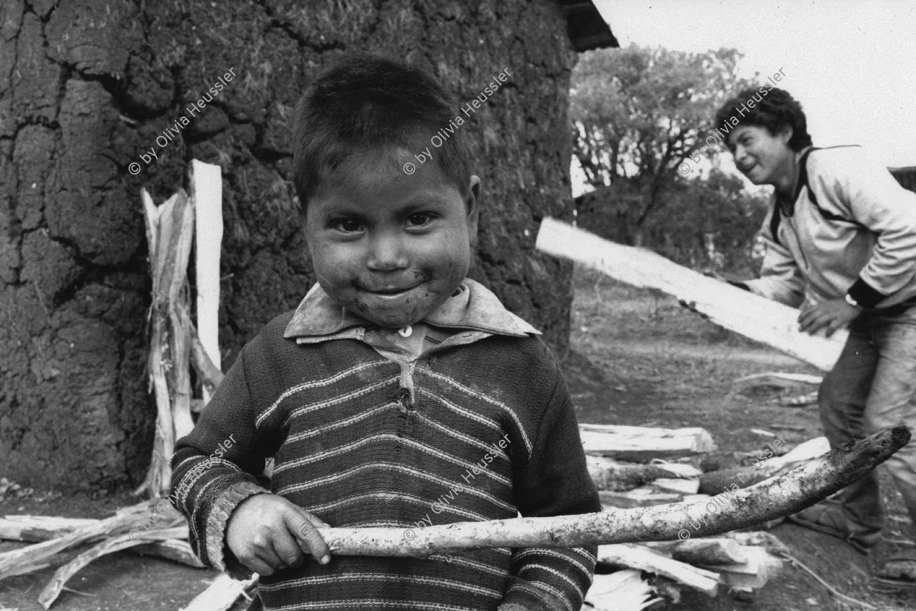 Image of sheet 19890010 photo 25: Indigener Knabe mit Holz vor einem Adobe-Haus, San Christobal de las Casas, Chiapas. Mexico 1989.