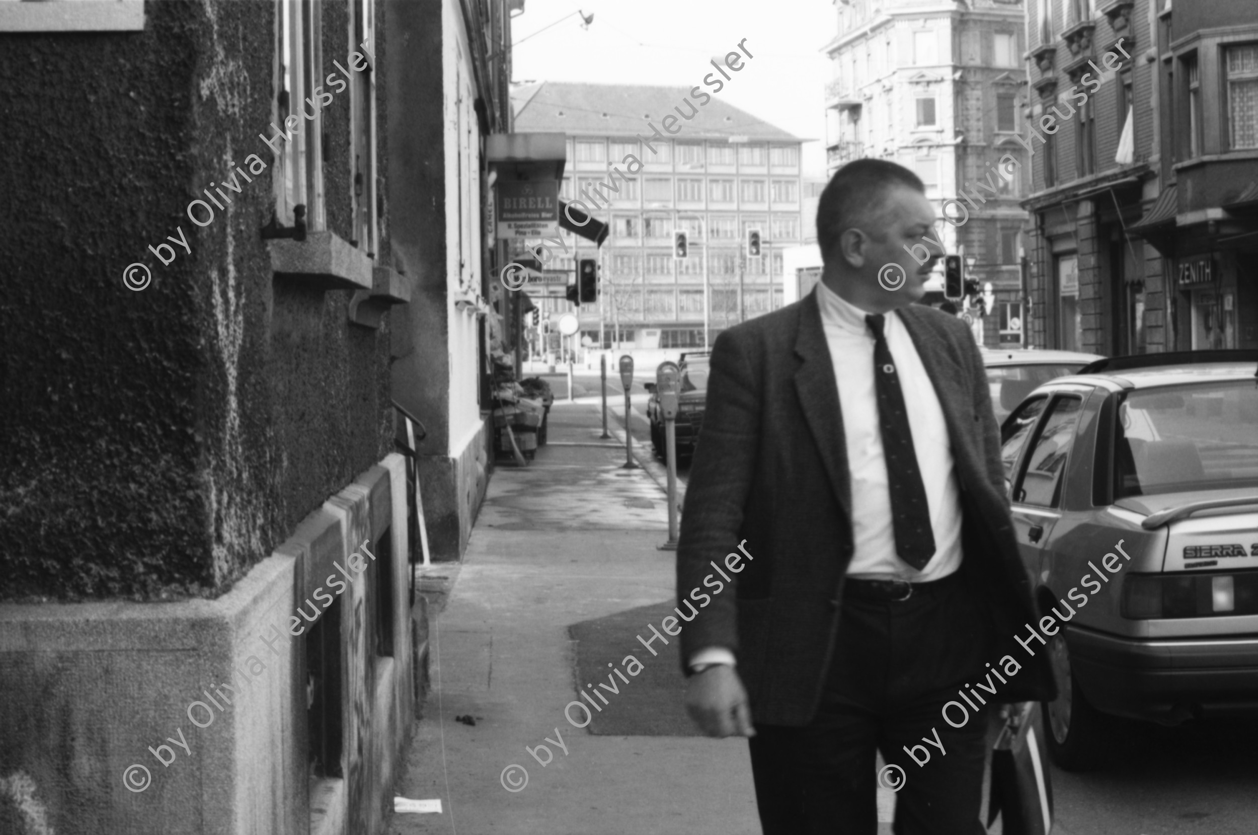 Image of sheet 19890160 photo 0: Am Dreieck, der Zweierstrasse 49/51 stehen die Bagger zur Markierung was alles weg kommt. Als Schablone am Boden. Die Häuser. Die Transparente. Ein Bewohner im Büro. Ein Laden. Das Café Zweier ist weg. Spiegelungen im Fenster. Kuchen liegen da. Zürich Hausbesetzung 1989
