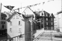 Image of sheet 19890160 photo 7: Am Dreieck, der Zweierstrasse 49/51 stehen die Bagger zur Markierung was alles weg kommt. Als Schablone am Boden. Die Häuser. Die Transparente. Ein Bewohner im Büro. Ein Laden. Das Café Zweier ist weg. Spiegelungen im Fenster. Kuchen liegen da. Zürich Hausbesetzung 1989