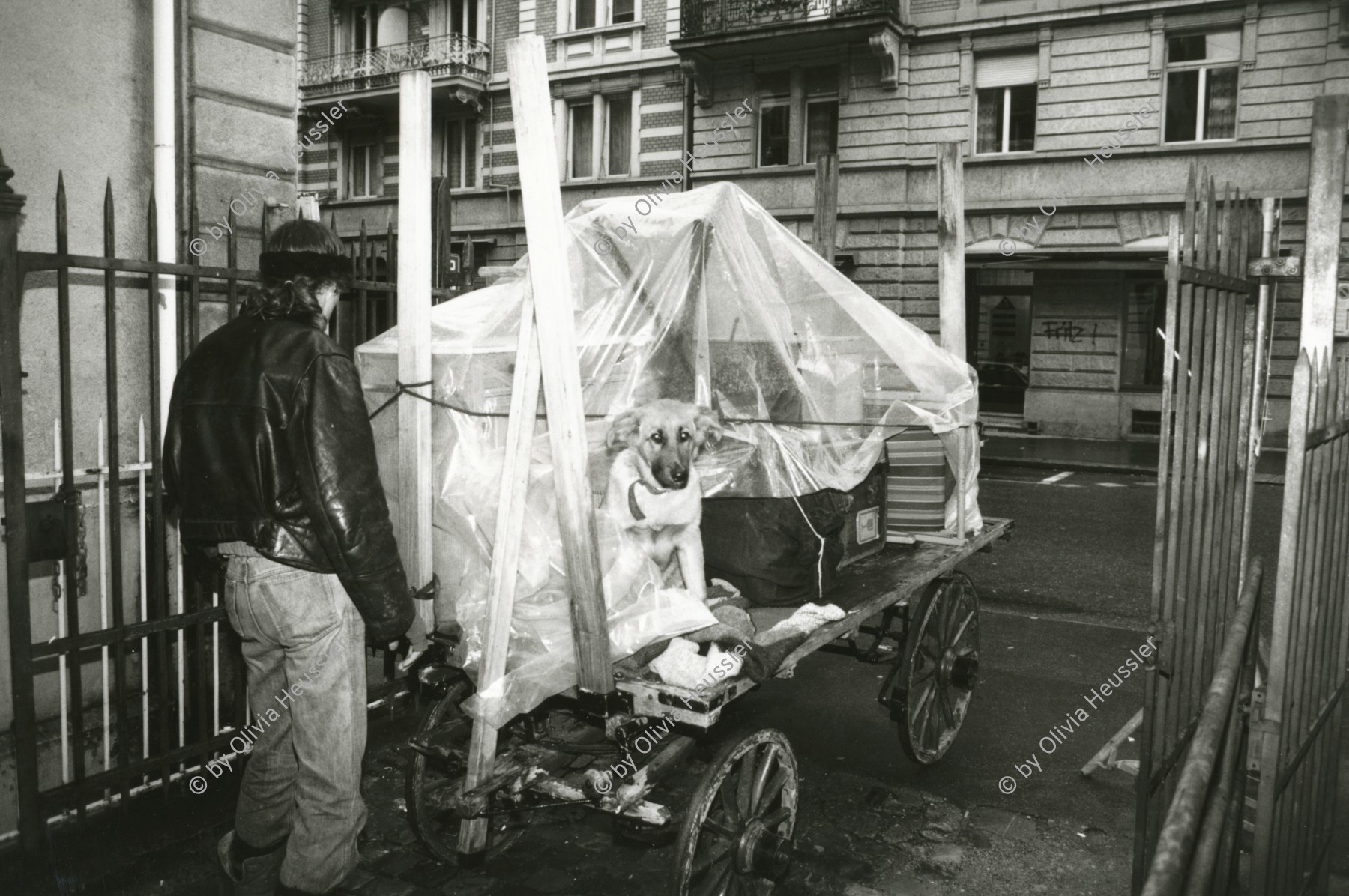 Image of sheet 19890190 photo 6: An der Bäckerstrasse im Kreis 4. Aussersihl Ein Mann zügelt auf einem Leiterwagen Handwagen Karren seine Sachen mit Hund! Zürich 1989 Wohnen Wohnungsnot √