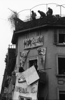 Image of sheet 19890280 photo 12: mit Transparent SpeckulAir. Entieeignet. falsch geschrieben steht an der Hausmauer. frisch gemalt. Von Männern die sich der Hausfassade entlang abseilten. Spray Graffitti Zürich 1989 Wohnungsnot