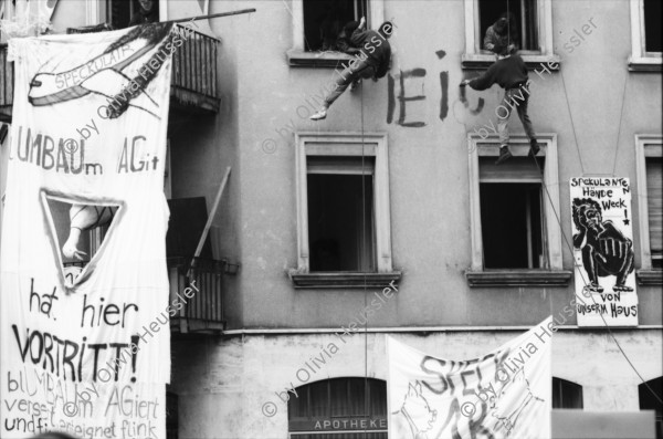 Image of sheet 19890280 photo 6: frtsg. 890270 Demo Wohnen tut Not. Ankerstrasse 124 mit Transparent SpeckulAir. Entieeignet. falsch geschrieben steht an der Hausmauer. frisch gemalt. Von Männern die sich der Hausfassade entlang abseilten. Spray Graffitti Zürich 1989 Wohnungsnot