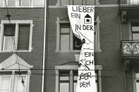 Image of sheet 19890310 photo 9: Die Limmatstrasse 217 ist besetzt, die Wirtin schneidet Transparent ab, Zürich 1989.
Zürich Wohnungsnot Besetzung Wohnen