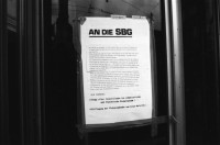 Image of sheet 19890370 photo 16: Frau steht eingepackt in der Sonne. Welteinheit durch Weltordnung' steht da auf einer Tafel einer religiösen Sekte. Ein Karton AKW wird an der Demonstration gegen Atomkraftwerke herumgetragen. Transparent: 'Für die sofortige Stilllegung der herrschenden Klasse' Portrait von Viktor Braun. Giovanni Schuhmacher mit Fahne und dem Anarchisten A vor Bundeshaus in Bern. Eine Frau muss über die Abschrankung der Polizei auf den Bundeshausplatz steigen . Meine Bilder im Hotel Bern. Nicaragua von sieben Schweizer Photographen und Photographinnen. Reithalle Interieur Skateborder Bern 1989