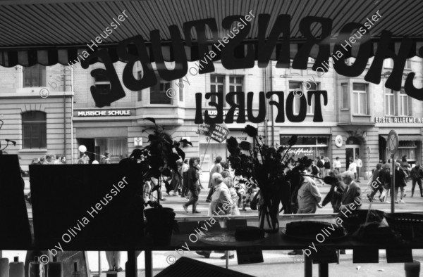 Image of sheet 19890370 photo 18: Frau steht eingepackt in der Sonne. Welteinheit durch Weltordnung' steht da auf einer Tafel einer religiösen Sekte. Ein Karton AKW wird an der Demonstration gegen Atomkraftwerke herumgetragen. Transparent: 'Für die sofortige Stilllegung der herrschenden Klasse' Portrait von Viktor Braun. Giovanni Schuhmacher mit Fahne und dem Anarchisten A vor Bundeshaus in Bern. Eine Frau muss über die Abschrankung der Polizei auf den Bundeshausplatz steigen . Meine Bilder im Hotel Bern. Nicaragua von sieben Schweizer Photographen und Photographinnen. Reithalle Interieur Skateborder Bern 1989