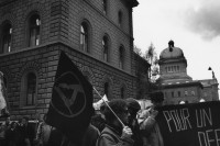 Image of sheet 19890370 photo 25: Demonstration gegen Atomkraftwerke  Transparent: 'Für die sofortige Stilllegung der herrschenden Klasse'  Giovanni Schuhmacher mit Fahne und dem Anarchisten A vor Bundeshaus in Bern. Bern 1989 √anti nuclear power  AKW Schweiz Switzerland Europe anarchist flag