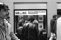 Image of sheet 19890370 photo 5: Frau steht eingepackt in der Sonne. Welteinheit durch Weltordnung' steht da auf einer Tafel einer religiösen Sekte. Ein Karton AKW wird an der Demonstration gegen Atomkraftwerke herumgetragen. Transparent: 'Für die sofortige Stilllegung der herrschenden Klasse' Portrait von Viktor Braun. Giovanni Schuhmacher mit Fahne und dem Anarchisten A vor Bundeshaus in Bern. Eine Frau muss über die Abschrankung der Polizei auf den Bundeshausplatz steigen . Meine Bilder im Hotel Bern. Nicaragua von sieben Schweizer Photographen und Photographinnen. Reithalle Interieur Skateborder Bern 1989