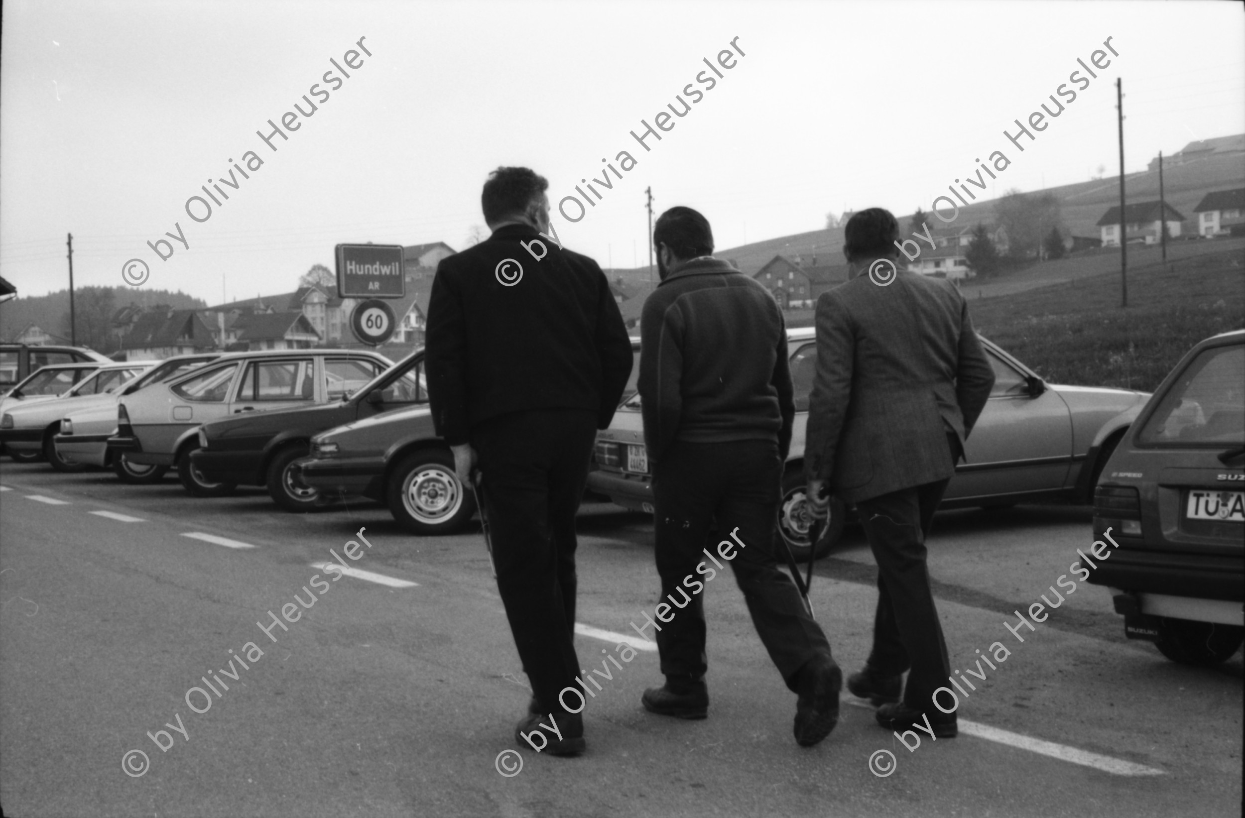 Image of sheet 19890420 photo 35: Däne Daniel Salzgeber und Mäse Spalinger Cathys Bauch als Zigarettenraucher In. Chemie Fabrik Lonza. Im Appenzell Ausserrhoden marschieren die Männer zum letztenmal an die von ihnen allein bestimmte Landsgemeinde. Sie tragen Dolche am Gürtel. Auch im Schaufenster der Bäckerei liegt ein Säbel. Junge Burschen auf dem Weg zur Landsgemeinde in Hundwil. Kanton Appenzell 
Hundwil is a municipality in the canton of Appenzell Ausserrhoden in Switzerland 1989