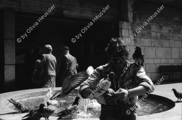 Image of sheet 19890470 photo 12: Ziviler Polizist mit Funk am Helvetiaplatz. drittes 3. Refugium der kurdischen Asylbewerber Innen. am Werplatz in der GBH Strassburgstr. Ligihaus. Städtische Liegenschaftsverwaltung Stadt Zürich Tauben an einem Brunnenrand. Portrait Felix von Muralt am Bahnhof vor Uhr ohne Zeiger. Plattenspieler. Transparent hängt an besetzten Haus an Ankerstr. 124. Enteignet. 'Nur noch ständig für die Miete schaffen? Greifen wir lieber Alle zu den Werkzeugen!! kommt Wohnen vor Eigendumm. Fahrradpneu mit Schutzblech am falschen Ort. Zweierstrasse wird
bemalt. Taube und kanninchen von einem Zauberer in bepflanzten Hof von abgebrochener Zweierstasse 55  Dreieck Wohnungsnot housing protest occupy Zürich 1989 Switzerland Schweiz Suisse