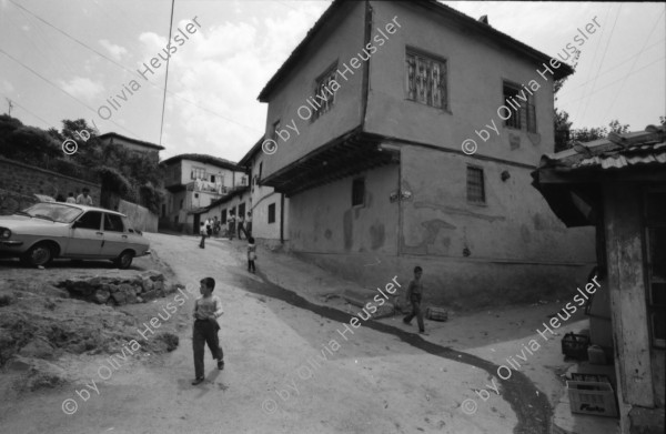 Image of sheet 19890540 photo 14: Moschee Kocatepe Schuhe stehen draussen (Tagi). Melonen stehen wie Kanonenkugeln vor der Moschee. Mann vor Kinoreklame mit Totenkopf. Umzug. Möbel steht auf der Strasse mit eingebautem Spiegel. Treppe zur Altstadt. Mann sitzt Frau arbeitet. Kale Ankara Türkisches Haus. Innenhof. Wolle wird zum trocknen aufgehängt. Uebersicht. Kinder. Frauen arbeiten mit Wolle. Frauen und Kinder kommen entgegen. Mercedes Benz. Innenstadt. Soldat sitzt in Kaffee. Männer essen am Markt. Marktszene. Innestadt Altstadt. Mann. Türkei Ankara 1989