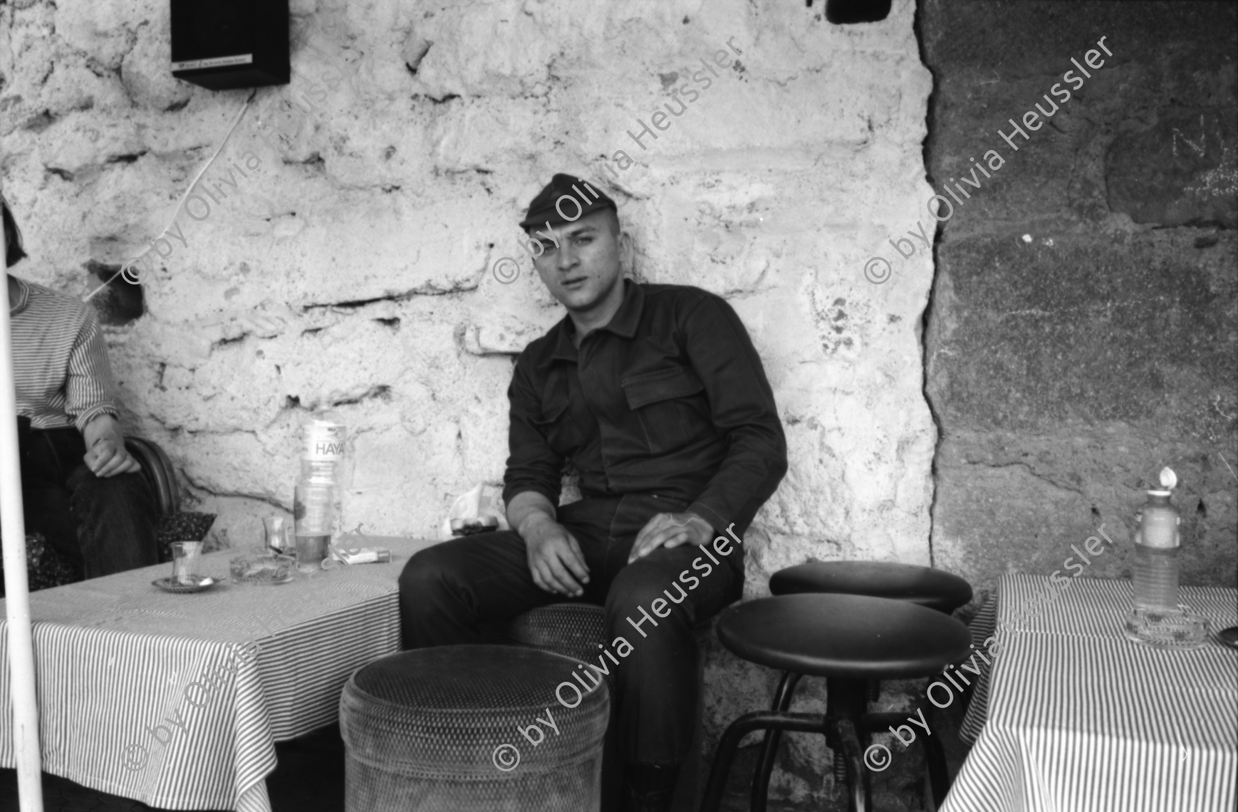 Image of sheet 19890540 photo 27: Moschee Kocatepe Schuhe stehen draussen (Tagi). Melonen stehen wie Kanonenkugeln vor der Moschee. Mann vor Kinoreklame mit Totenkopf. Umzug. Möbel steht auf der Strasse mit eingebautem Spiegel. Treppe zur Altstadt. Mann sitzt Frau arbeitet. Kale Ankara Türkisches Haus. Innenhof. Wolle wird zum trocknen aufgehängt. Uebersicht. Kinder. Frauen arbeiten mit Wolle. Frauen und Kinder kommen entgegen. Mercedes Benz. Innenstadt. Soldat sitzt in Kaffee. Männer essen am Markt. Marktszene. Innestadt Altstadt. Mann. Türkei Ankara 1989
