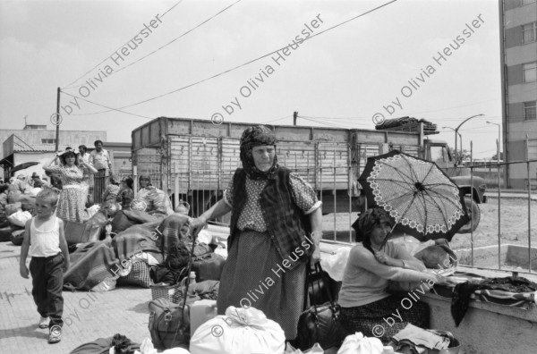 Image of sheet 19890600 photo 26: 34. Tag des Exodus türkischstämmiger 'Ausflügler', wie sie in Bulgarien genannt werden. Deportierte in der Türkei. Lastwagenschlage an der Türkisch-Bulgarischen Grenze. Auf dem Bahn-Quai von Kapikule sitzen und liegen hunderte von Türkischstämmigen BulgarInnen mit ihren Familien erschöpft in einem grossen elenden Durcheinander. Die Türkische Fahne bedeutet für viele das Symbol eines 'freien' Landes. In Bulgarien hat man sie gezwungen ihre Namen und ihre Sprache zu ändern. Oezal benützt die ca 300'000 Bulgaren für seine Wahlkampagne. Viele Kinder weinen unaufhörlich vor Erschöpfung. In Bergen von Hab und Gut entdecke ich ganze Wohnungseinrichtungen. Der Duty Free Laden ist geschlossen. Die Güterwagen, in denen die Menschen tagelang eingesperrt reisen mussten, werden nach ihrer Leerung wieder zurückfahren und noch mehr Familien in ihr Unglück stürzen. Türkei Turkey Bulgarian Refugees 1989